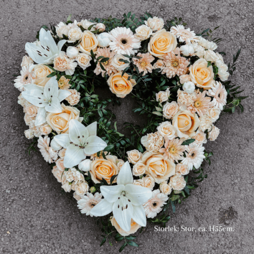 Öppet begravningshjärta i storlek stor. Hjärtat går i aprikosa toner med inslag av vita liljor.