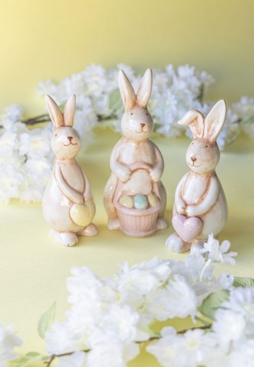 Keramisk påskkanin med korg fylld av ägg