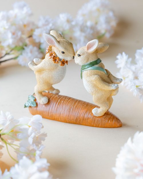 Påskdekoration med kaniner stående på morot